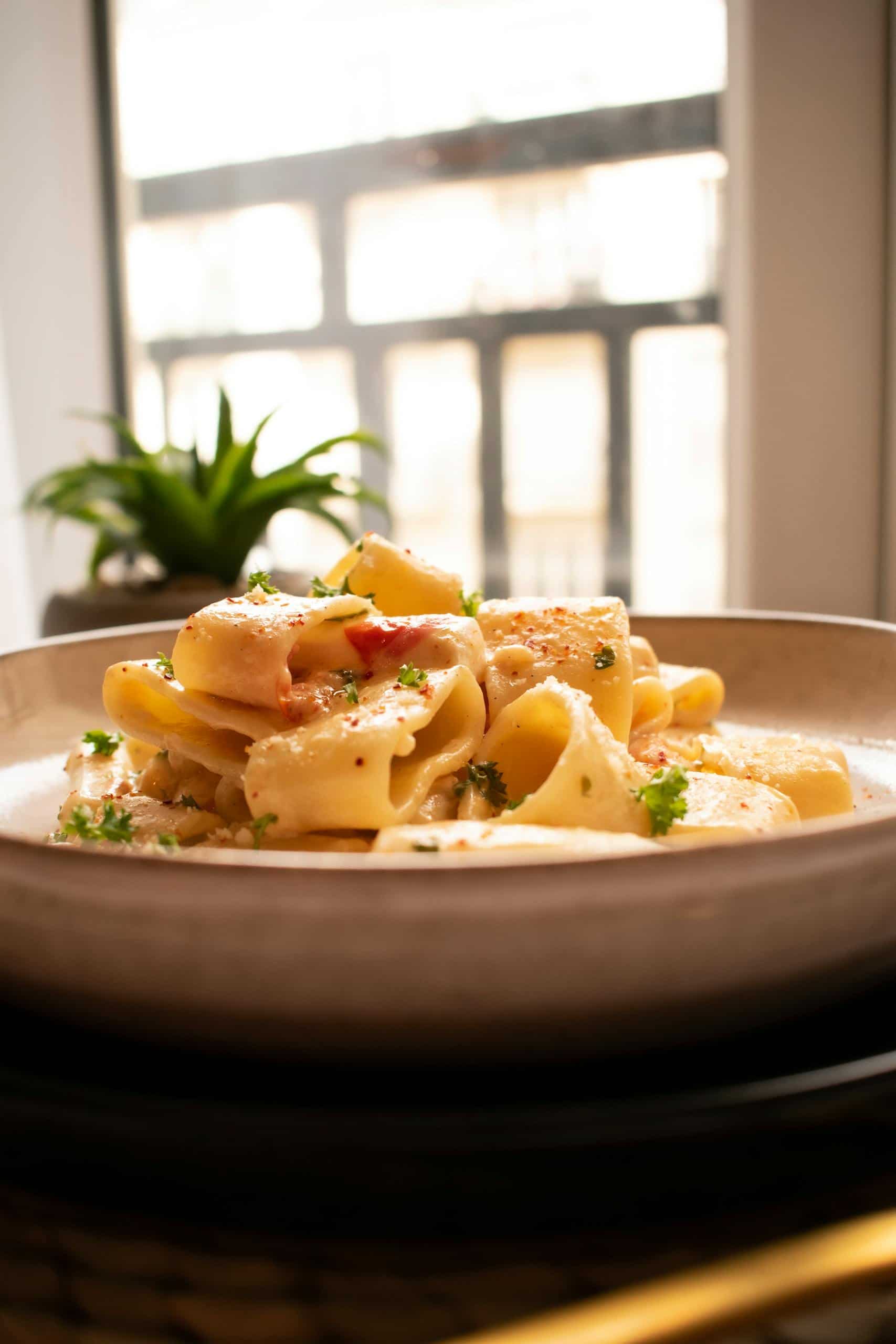 Delicious creamy pasta garnished with parsley, perfect for a cozy meal at home.