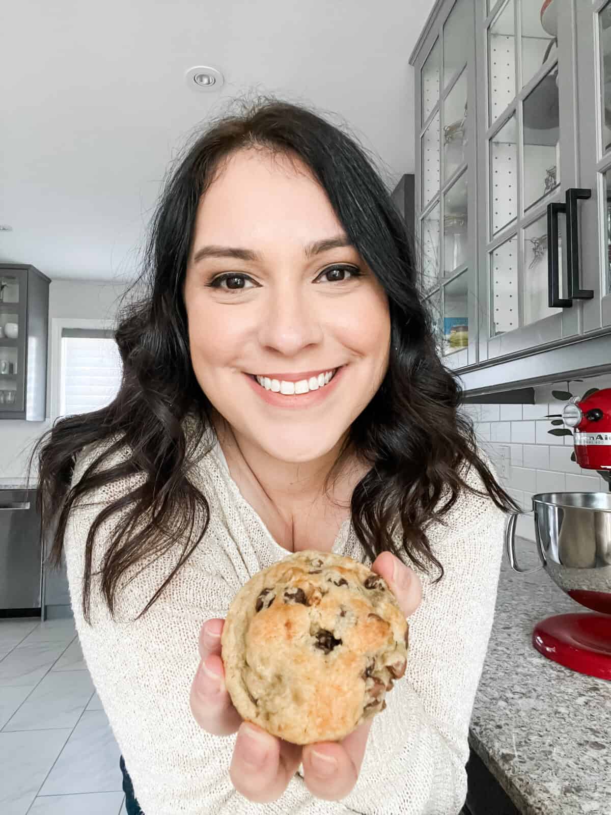 Bruna's Headshot holding a chocolate chip cookie