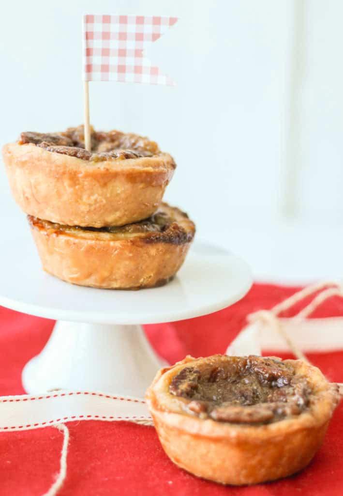 Freshly baked pecan raisin buttertarts in a cake stand