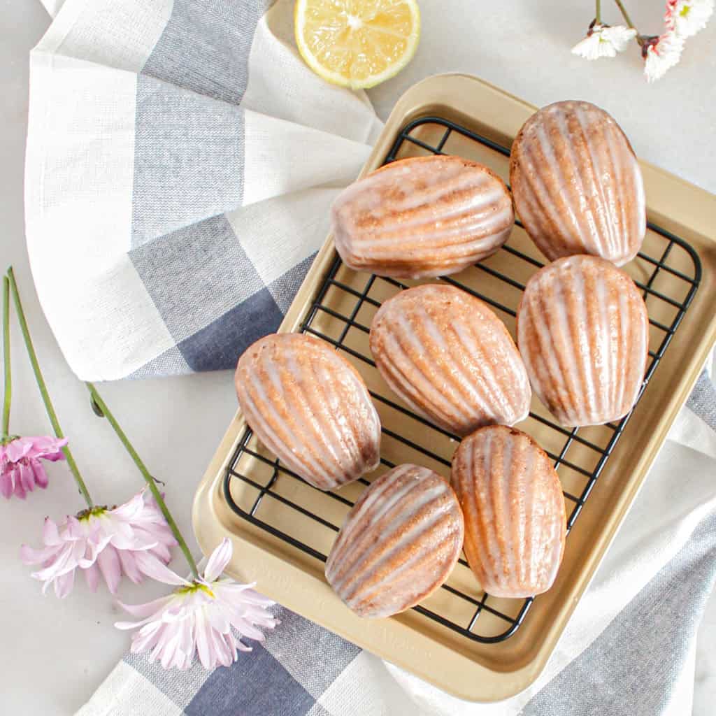 Lemon madeleines resting over a baking tray