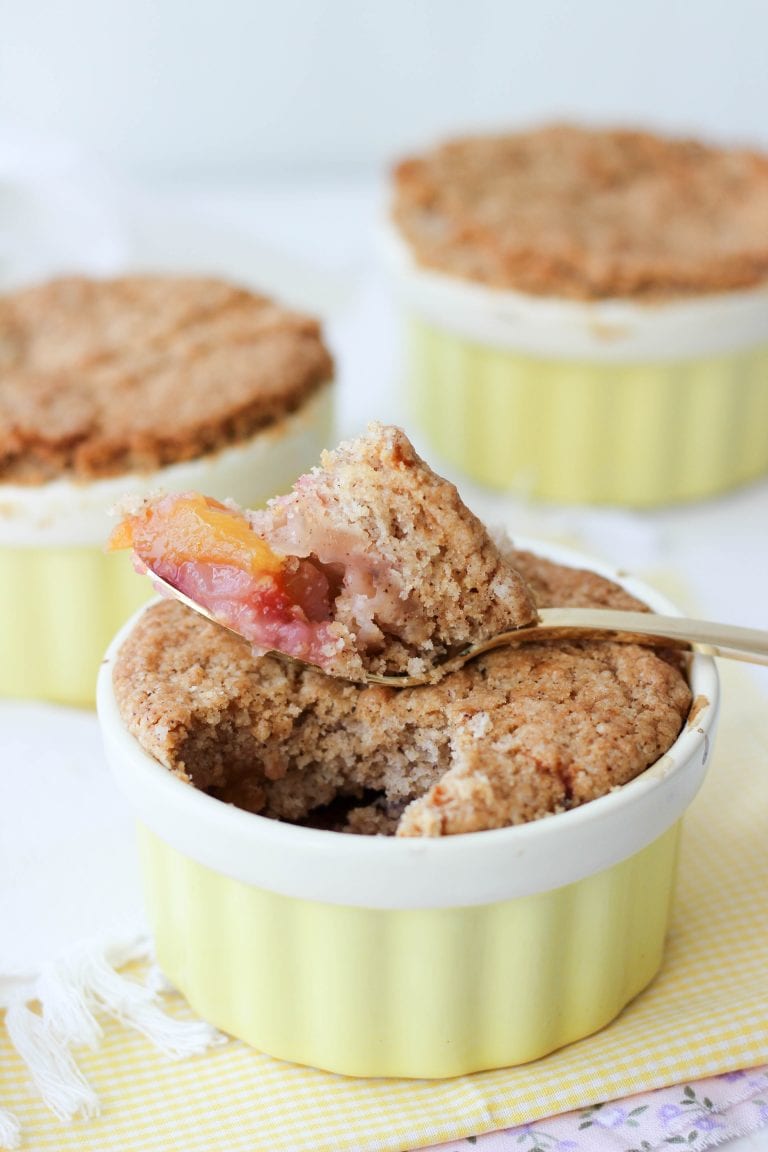Baked peach and plum cobbler with golden topping in a ramekin