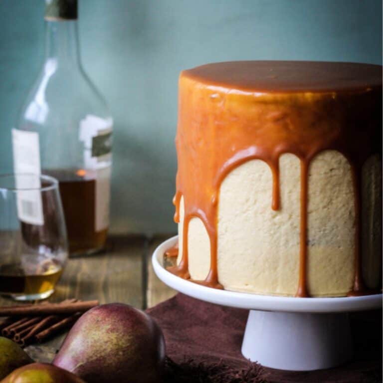 Spiced pear cake in a white cake stand ready to be served.