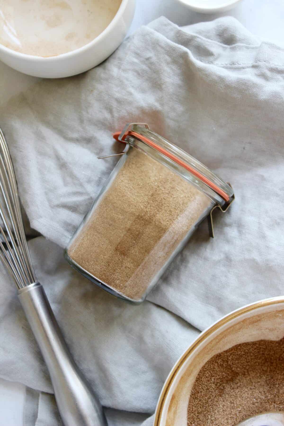 Jar of homemade cinnamon sugar made with granulated sugar and ground cinnamon.