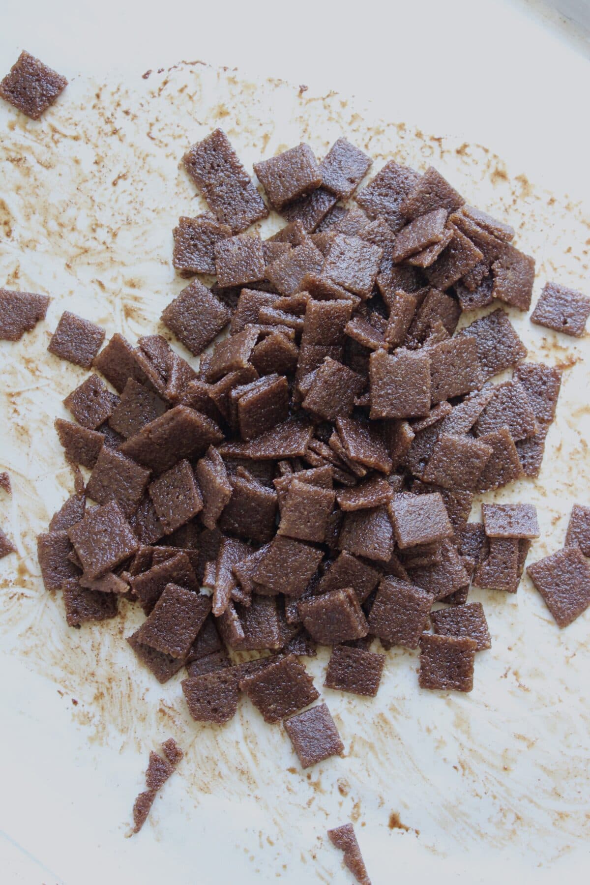 Cutting homemade cinnamon chips into small square pieces after baking.