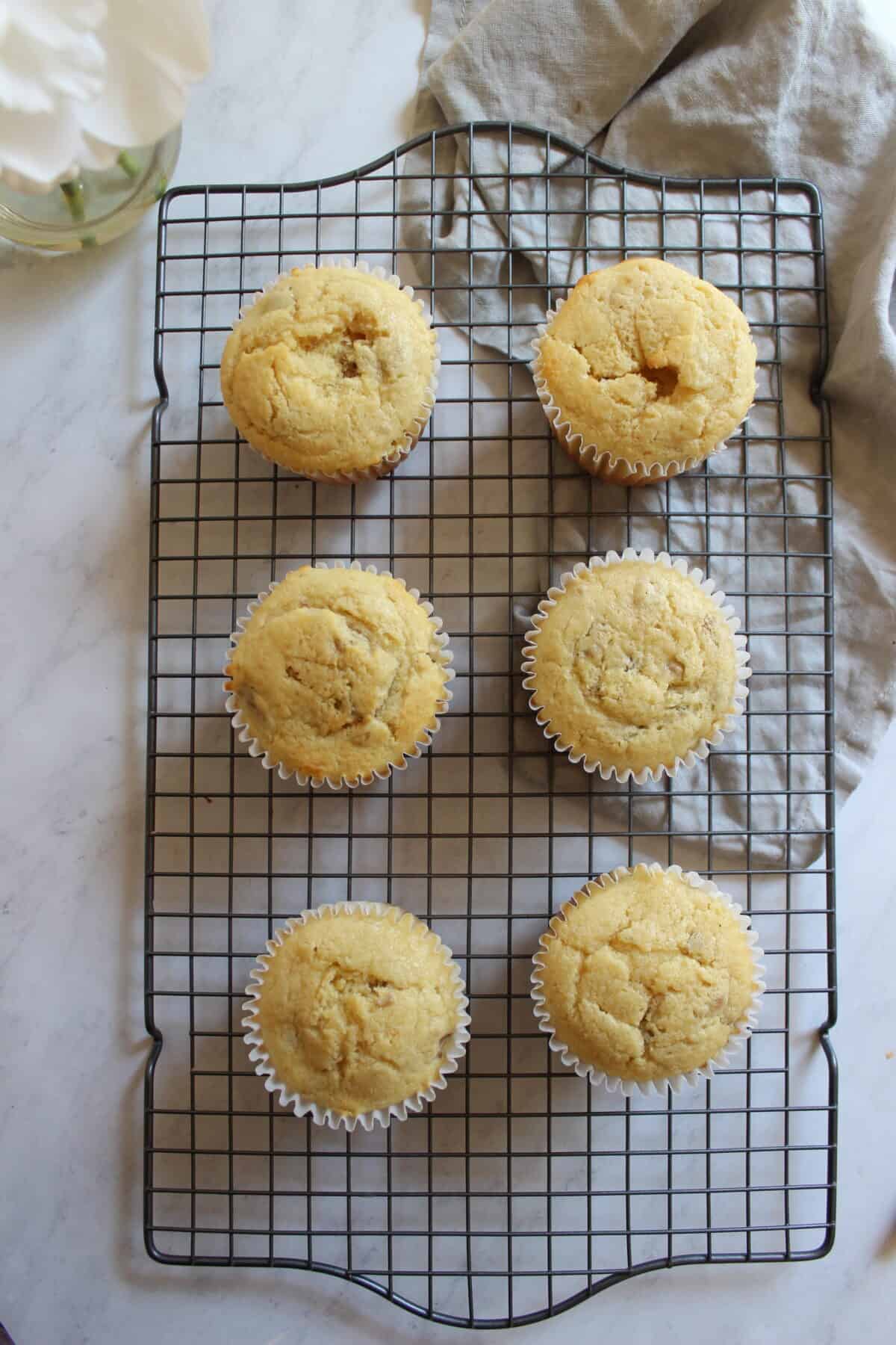 Lemon cupcakes cooling in cupcake liners on a wire rack