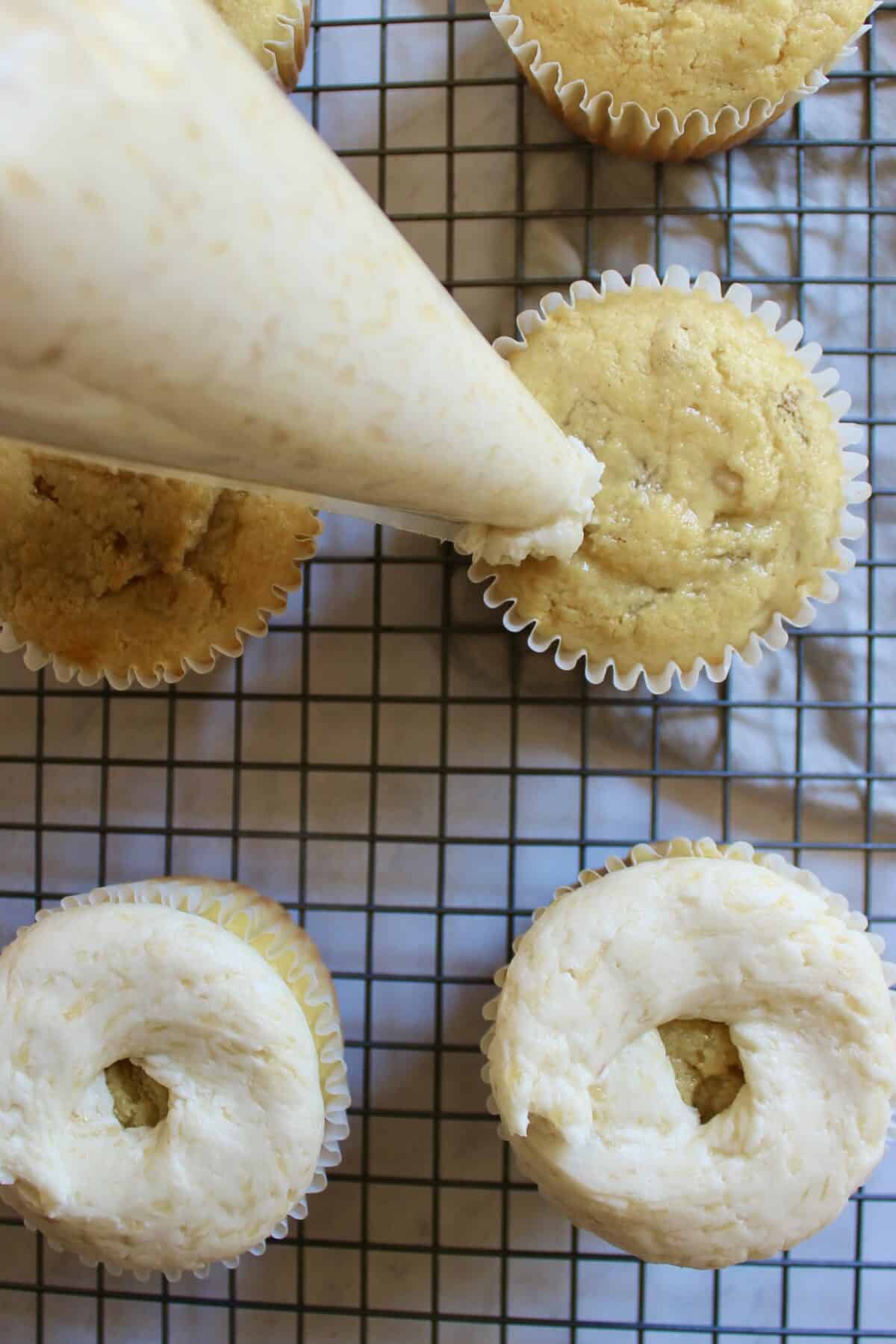 Pear cupcakes being frosted with buttercream.